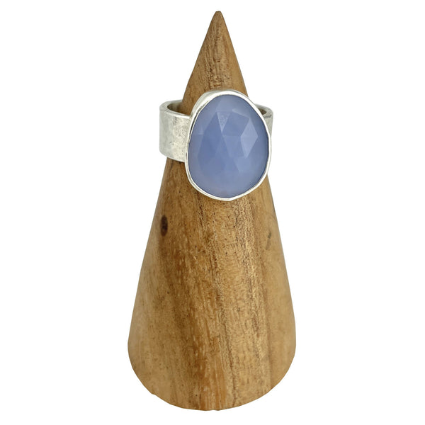 Beautiful rose cut blue chalcedony. It is set in fine and sterling silver. The ring band is 8mm wide and has a hammered finish.