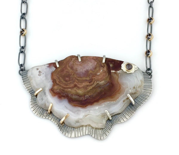 Necklace featuring a polished Crazy Lace Agate slab. It is accented with a rose cut brown diamond.