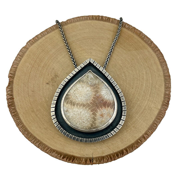 Gorgeous necklace featuring a fossil coral cabochon set in an oxidized fine and sterling silver shadow box setting.