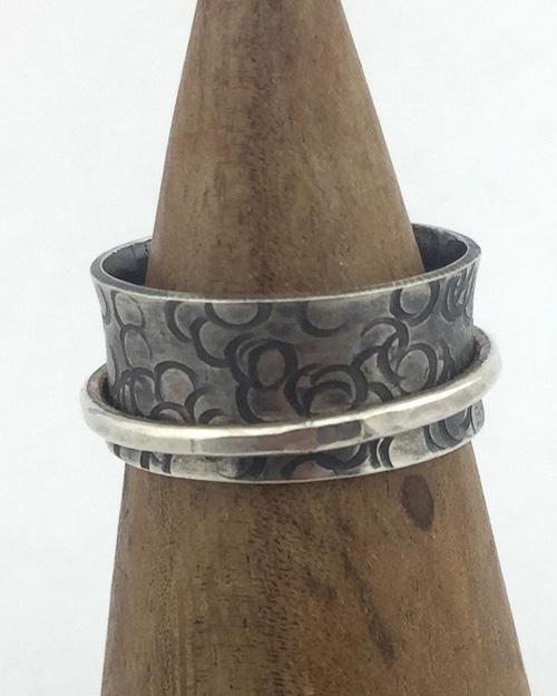 Close up of oxidized spinner ring with circles texture